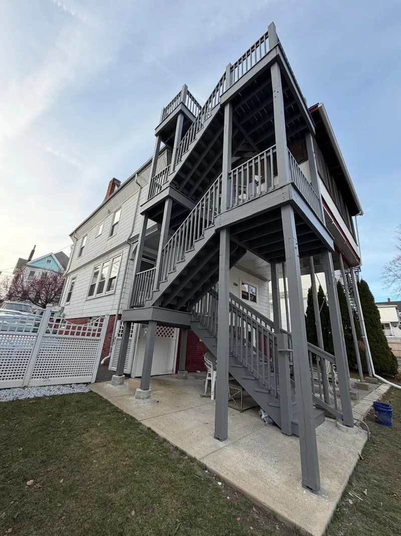 Repainted exterior staircase and porch railings on a multi-family home