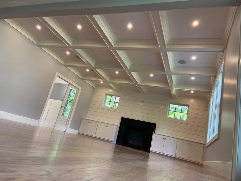 Freshly painted great room with coffered ceiling and white trim